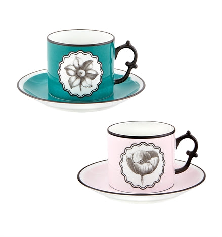 Vista Alegre | Lacroix - Herbariae Set features two porcelain teacup-and-saucer sets in turquoise and pink, each adorned with unique floral sketches and black trim.
