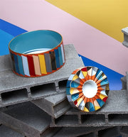 Vista Alegre | Futurismo Catchall Tray displayed on cinder blocks, featuring multicolored, cylindrical and fluted bowls, embodying modern artistic reinvention.