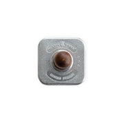 Nordic Ware | Gingerbread cookie stamp featuring a round metal design with a brown wooden handle, perfect for creating festive holiday cookies.
