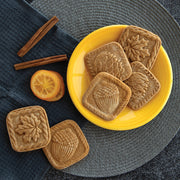 Nordic Ware | Fall Forest Springerle Cookie Stamps on display with cookies and cinnamon sticks, showcasing intricate autumn designs for seasonal baking.