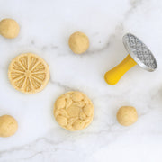 Nordic Ware | Citrus Cookie Stamps shown with a lemon cookie and cookie cutter, highlighting the citrus-inspired designs perfect for enhancing homemade cookies.