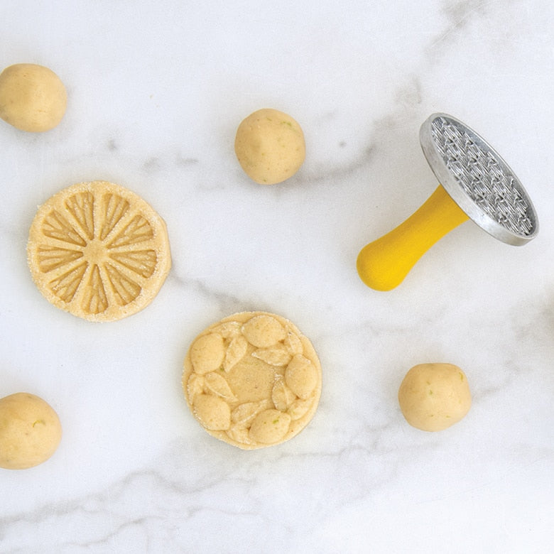 Nordic Ware | Citrus Cookie Stamps shown with a lemon cookie and cookie cutter, highlighting the citrus-inspired designs perfect for enhancing homemade cookies.