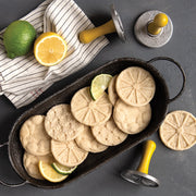 Nordic Ware | Citrus Cookie Stamps displayed with cookies and lemon slices, highlighting their intricate citrus designs, perfect for enhancing the flavor of Key Lime or lemon shortbread cookies.