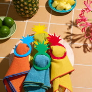 Atelier Saucier | Pineapple Napkin Ring Set displayed on a tropical-themed table with vibrant napkins and fruit, embodying Athens Cooks' curated kitchen elegance.