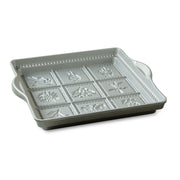 Nordic Ware | English Shortbread Pan featuring a white square tray with handles, designed to create nine flower and fruit patterns for baking delightful shortbread.