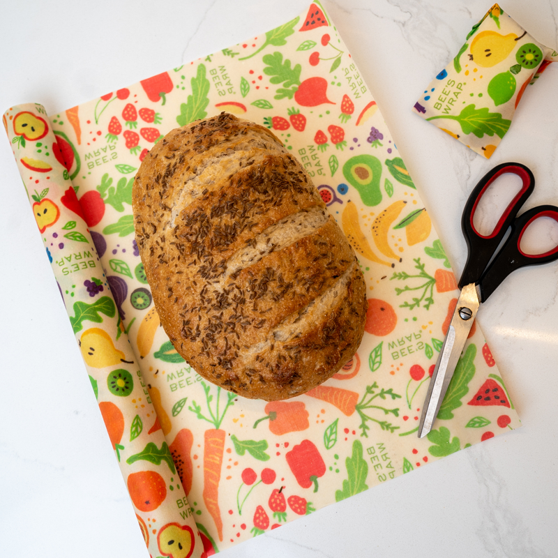 Bee's Wrap - New! Garden Party - Cut-to-Size Roll Wrap on a table with scissors, showcasing its versatility for reusable food storage.