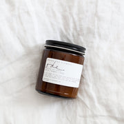 Among the Flowers | Essential Oil + Soy Wax Candle Domes in an amber-glass jar with a black lid, featuring jasmine, bergamot, and orange scents.