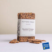 Potters Table - Gluten-Free Seeded Crisps with a 2023 Good Food Award label, featuring artisanal seed crackers wrapped in branded paper, ideal for health-conscious snacking.