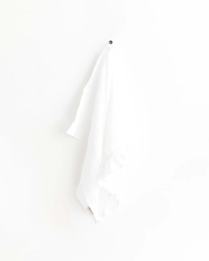 MagicLinen - Ruffle trim tea towel hanging on a hook, showcasing its soft, durable linen texture and practical loop for easy kitchen use.