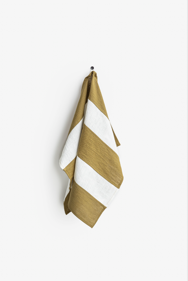 Striped linen tea towel on hook, showcasing zero-waste craftsmanship; features a hanging loop, emphasizing durability and absorbency, ideal for eco-friendly kitchen use.