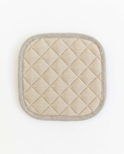 Close-up of MagicLinen linen pot-holder with quilted detailing and hanging loop, part of a stylish kitchen set, perfect for heat protection.