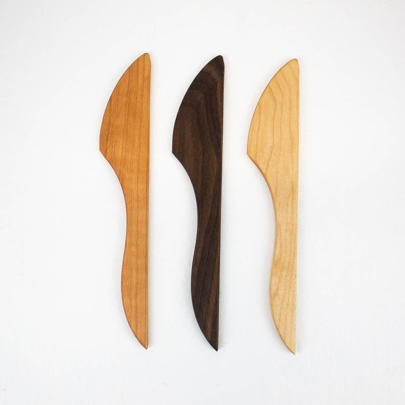 Collin Garrity wooden spreader knives in cherry, walnut, and maple, with ergonomic handles for spreading cheese and butter, reflecting Athens Cooks' curated kitchen tool selection.