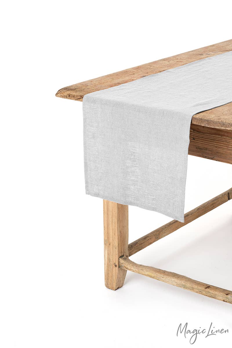 MagicLinen linen table runner displayed on a wooden table, offering both protection and style, available in various colors and sizes.