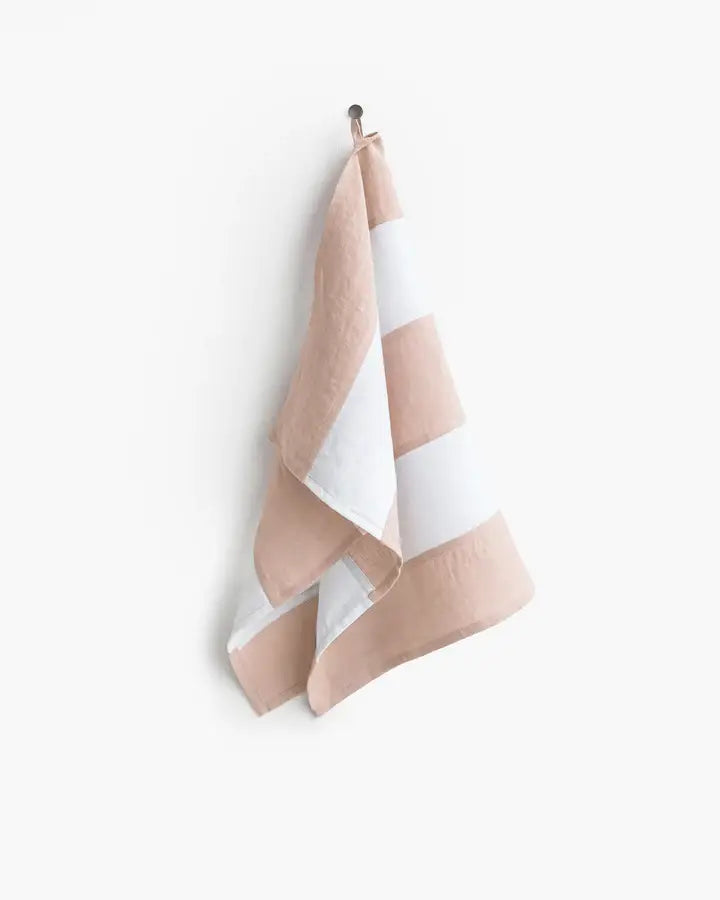 Striped linen tea towel on a hook, featuring a hanging loop, part of MagicLinen's zero-waste collection from Athens Cooks.