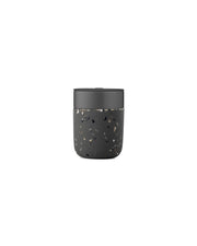 W&P Reusable Ceramic Mug: Terrazzo Blush, 16 oz, with a black lid and speckled surface, featuring a splash-resistant slide-lock tab for easy sipping.