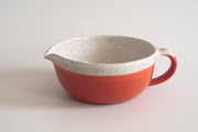 RachaelPots - Salad Dressing Bowl: Coral, a red and white speckled ceramic bowl with a garlic scraper, handle, and pour spout, perfect for creating dressings or marinades.