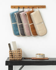 MagicLinen double oven mitts hanging on a wall, showcasing their protective design and eco-friendly linen material, ideal for cooking safety.