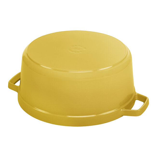 Staub | Round Cocottes - 5.5 qt Citron, shown upside-down with handles, showcases its durable enameled cast-iron design ideal for versatile cooking tasks.