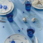 Royal Copenhagen Spring 2026 Eggs Chamomile 6cm 2pc displayed in an elegant blue and white table setting with floral motifs and cobalt-blue glasses.