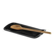 Emile Henry | Spoon Rest, Truffle: A ceramic spoon rest with a wooden spoon, featuring a curved design and groove for catching drips.