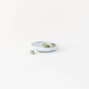 Sarah Kersten - Olive Dish: Basin Collection: Dove Grey features a small white plate holding green olives, ideal for versatile kitchen or dining use.