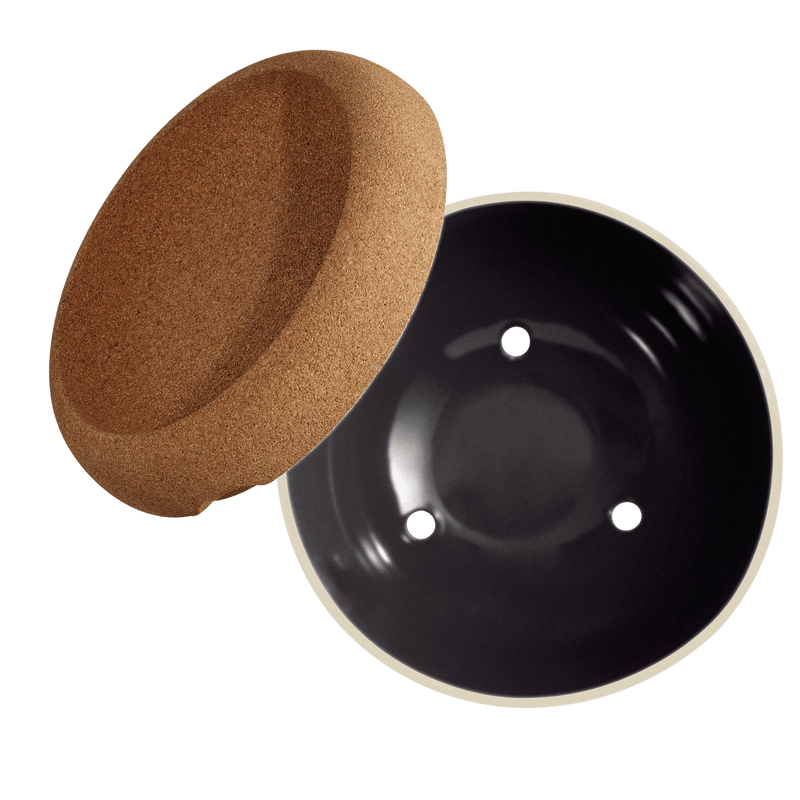 Emile Henry | Deep Storage Bowl, Truffle: A cork lid and black ceramic bowl with drainage holes for storing and preserving fruits and root vegetables effectively.