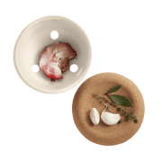 Emile Henry | Garlic Pot, Truffle, displayed with garlic cloves, bay leaves, and thyme on a cork trivet, showcasing its elegant, vented ceramic design for freshness.