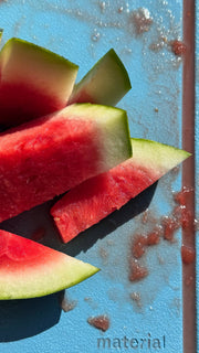 Material - The MK Free Board: Ocean, showcasing sliced watermelon on its innovative, plant-based surface with juice droplets, highlighting its non-porous, microplastic-free design.