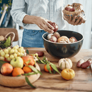 Emile Henry | Deep Storage Bowl, Truffle, displayed with fresh produce and root vegetables, showcasing its cork lid and ceramic base for optimal preservation.