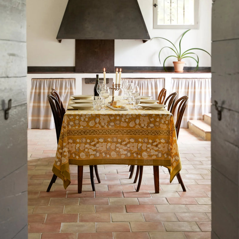 71 x 71 Forest Harvest Grey & Mustard Tablecloth featuring hand-printed sumptuous fruit and foliage design, set elegantly on a dining table.
