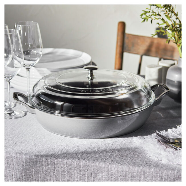 Staub | 12-inch Cast Iron Braiser with Glass Lid - Grenadine, ideal for moist, slow-cooked meals, made from enameled cast iron, featuring a domed glass lid.