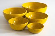 RachaelPots - Nesting Bowls Set Of Five: Nude/Light Blue, featuring a group of speckled yellow ceramic bowls, handmade and versatile for various kitchen needs.