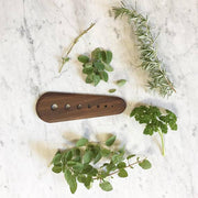 Collin Garrity - Herb Stripper: Walnut displayed with fresh rosemary, parsley, oregano, and thyme, showcasing its efficient leaf-stripping design on a marble surface.