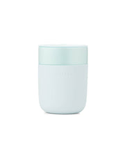 Reusable ceramic mug with a splash-resistant lid and a silicone sleeve for grip, ideal for reducing waste. W&P - Reusable Ceramic Mug: Terrazzo Charcoal, 16 oz.