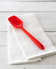 GIR Get It Right - GIR Ultimate Spoonula: Red shown on a white towel, featuring a deep bowl and flexible blade for versatile kitchen use.