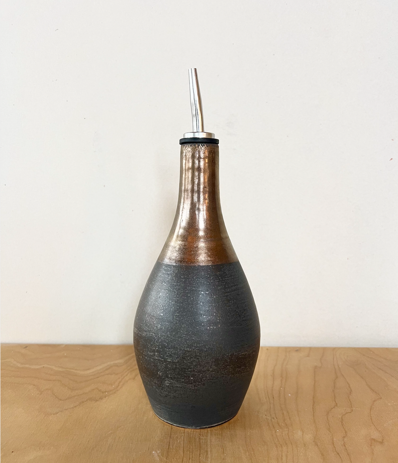 Jessica Wertz Ceramics - Black + Gold Oil Bottle, a handmade olive oil dispenser with a matte black base and gold drip top, features a stainless-steel pour spout.