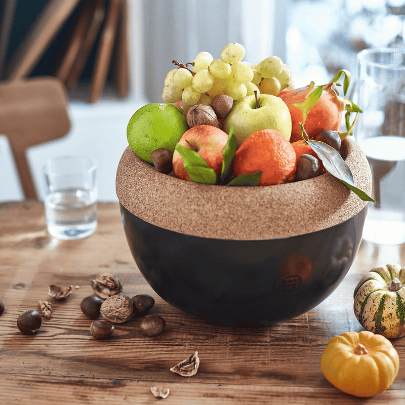 Emile Henry | Deep Storage Bowl, Truffle, on a rustic table, filled with assorted fruits and nuts, showcasing its cork lid and ceramic base for optimal food preservation.