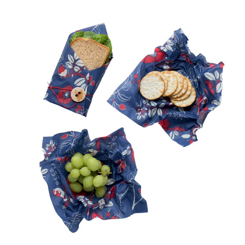 Bee's Wrap - Lunch 3 Pack - Botanical: eco-friendly wraps with floral patterns, holding a sandwich, crackers, and grapes, promoting sustainable lunch storage from Athens Cooks.