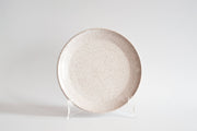 RachaelPots - Salad Plate: Sage; off-white ceramic with a brown speckled pattern, slightly upturned lip, displayed on a stand. Hand-thrown in Brooklyn, NY.