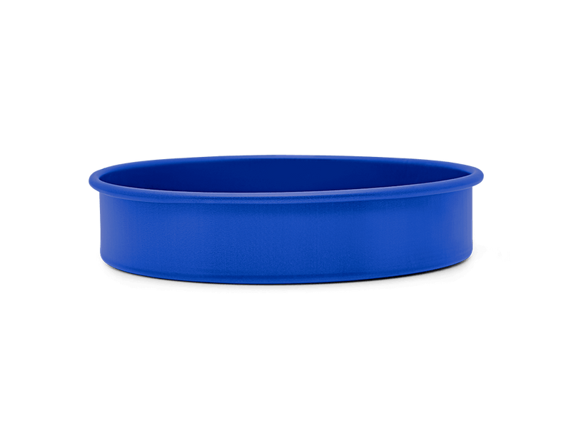 Great Jones | Patty Cake - Broccoli, a ceramic baking bowl with a wavy, corrugated bottom for easy release, displayed against a dark backdrop.