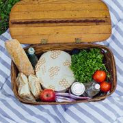 Bee's Wrap - Large 3 Pack Wraps shown in a basket with food, including a loaf of bread and fresh produce, highlighting their versatility for kitchen use.