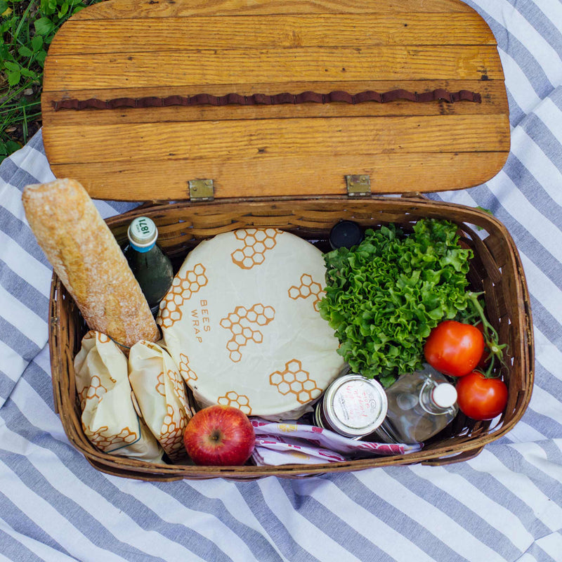 Bee's Wrap - Large 3 Pack Wraps shown in a basket with food, including a loaf of bread and fresh produce, highlighting their versatility for kitchen use.