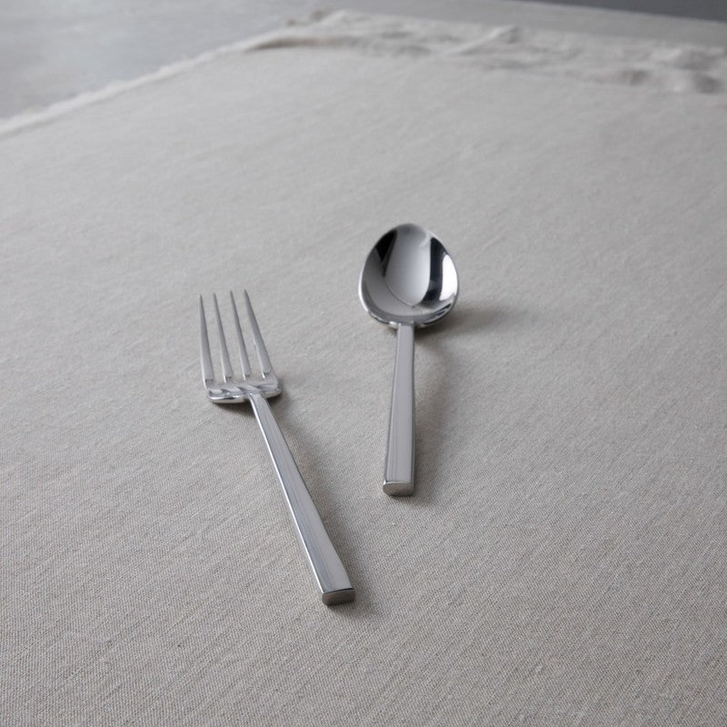 Zwiesel Fortessa | Arezzo Flatware Serving Set, Polished, featuring a sleek fork and tablespoon on a textured surface, exemplifying modern elegance and high-quality craftsmanship.