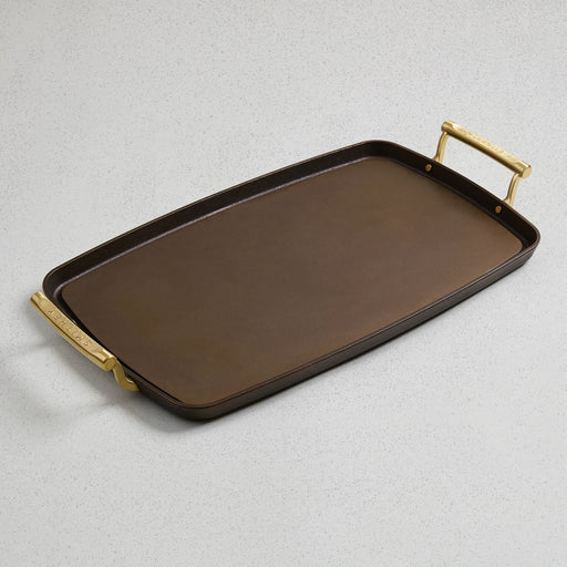 Smithey double burner cast iron griddle with polished surface and two gold-toned handles