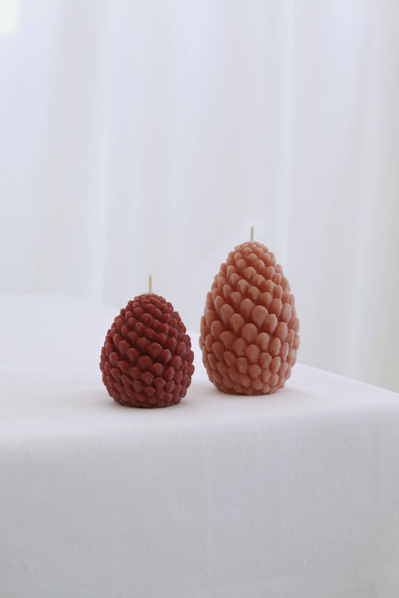 Mo&Co Home Exclusive: Sculpted Beeswax Pine Cone Candles, small and large, showcasing hand-poured craftsmanship and elegant design, perfect for holiday gatherings and gifting.