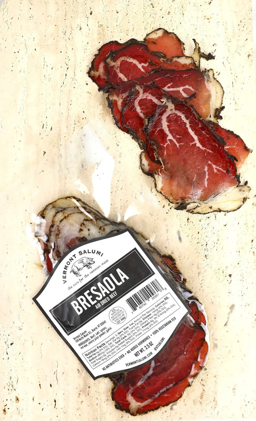 Vermont Salumi | Sliced Bresaola displayed in thin slices next to its packaging, showcasing air-dried, cured beef with thyme, juniper, and black pepper.