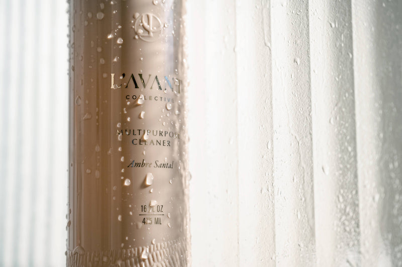 L'AVANT Collective - Multipurpose Cleaner Ambre Santal bottle with water droplets, 16 fl oz size, offering superior cleaning for kitchen surfaces in a sophisticated fragrance.