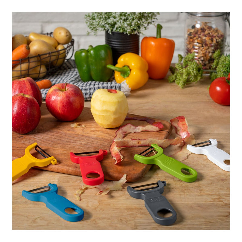 Kuhn Rikon | Original Swiss Peeler - Grey on cutting board with apples, surrounded by colorful peelers, showcasing its ergonomic design for efficient fruit and vegetable prepping.