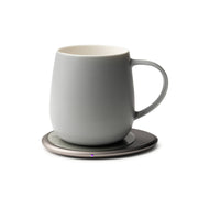 OHOM - Ui 3 Self-heating Mug Set: Jasmine White on a powered coaster, maintaining drink warmth and wirelessly charging phones, ideal for a refined kitchen experience.