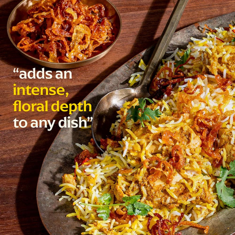 Diaspora Spices Co. - Kashmiri Saffron (Grade A Threads) enhances chicken biryani with intense, floral aroma; features spiced chicken, fried onions, and cilantro garnish.